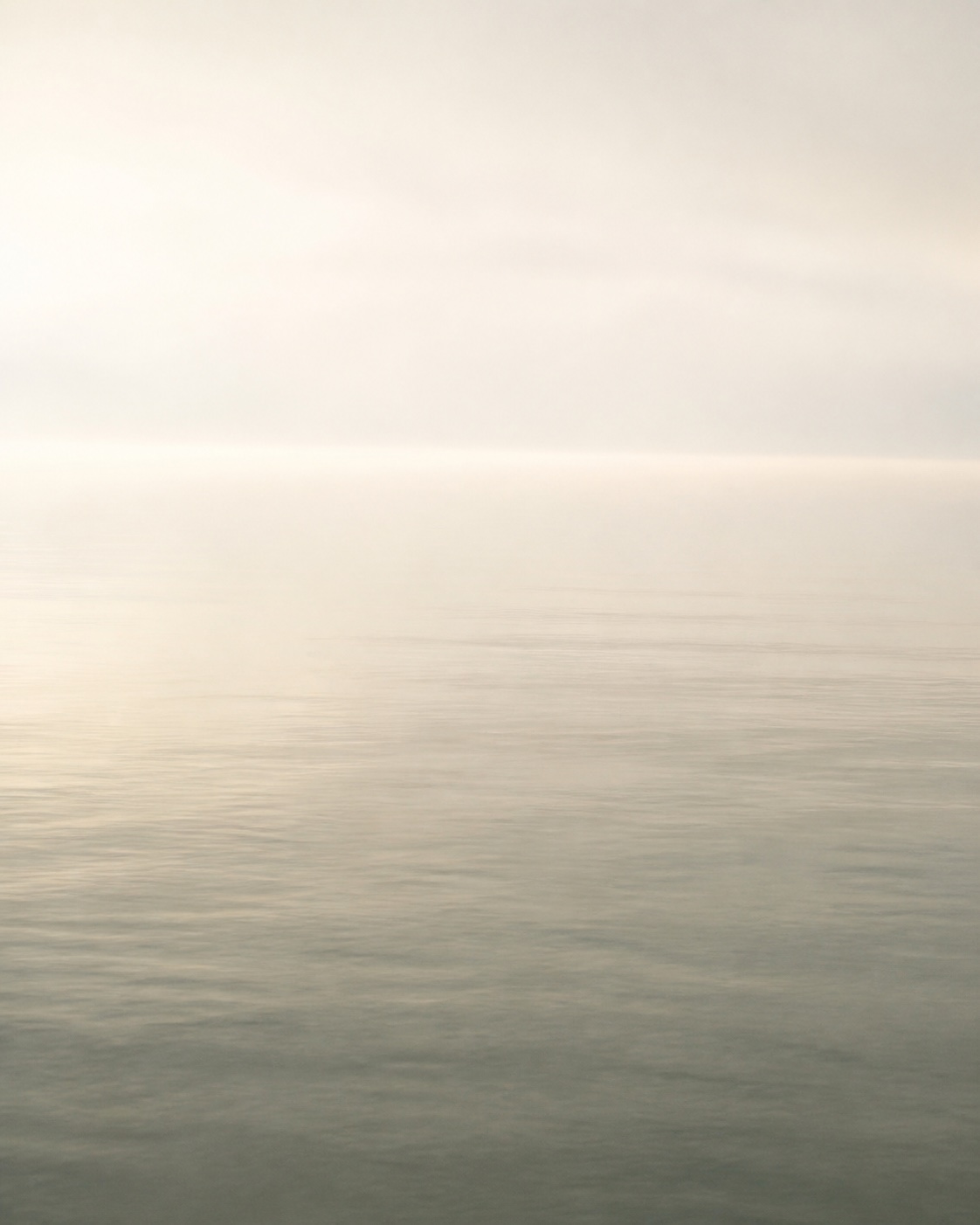 Calm open water disappearing into a misty horizon